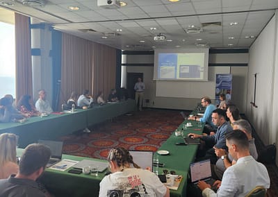 Speaker presenting to Inno2MARE consortium members seated in a conference room during the June 2025 meeting in Portorož.