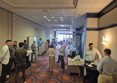 Inno2MARE participants in a conference room, listening attentively during a presentation, with notebooks and materials on the table.