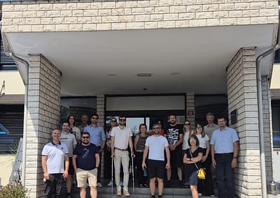 Aerial view of the Port of Koper, showing shipping containers, cranes, and port infrastructure along the Adriatic Sea.